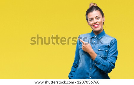 Young beautiful woman over isolated background cheerful with a smile of face pointing with hand and finger up to the side with happy and natural expression on face looking at the camera.