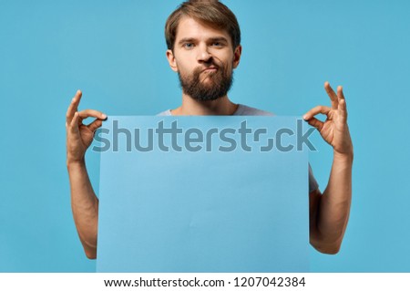 man poses face and holds mockup in front of him                          