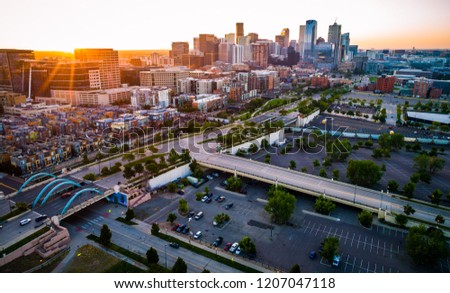 Sun rays star burst above Denver Colorado sunrise , golden hour sun rays across downtown skyline cityscape famous location in the mile high city , morning summer 2018 aerial drone view