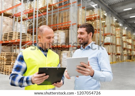 wholesale, logistic business and people concept - warehouse worker and businessman with clipboard and tablet pc computer Royalty-Free Stock Photo #1207054726