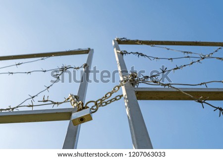 the gates of the border are locked and wound with barbed wire.
