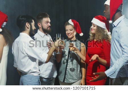 Group of friends making toast while celebrating New Year at party
