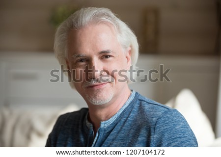 Close up portrait of smiling aged man with moustache looking at camera relaxing at home, happy senior male posing shooting indoors, elderly husband making professional photo or picture for album