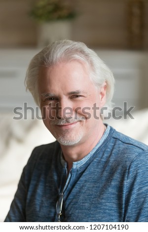 Close up portrait of smiling senior man with moustache posing for album picture, happy aged male looking at camera relaxing at home, elderly husband feel positive shooting indoors, making photo