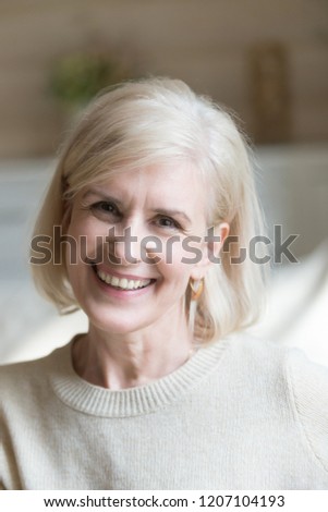 Close up of smiling aged woman feel positive and energetic looking at camera making picture, portrait of happy senior female posing for photo, excited elderly lady satisfied with life relaxing at home