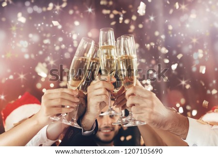 Cheers. New Year celebration. People holding glasses of champagne and making toast, holiday sparkling background