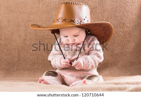 Funny baby in a big cowboy hat