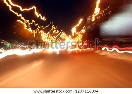 Abstract Motion speed, Light Tai background with blurred magic neon light curved lines. Lights and stripes moving fast over dark background. Orange backdrop from fast moving glow particles.
