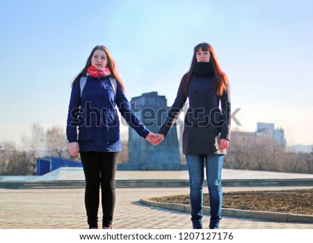 two sisters holding each other hands
