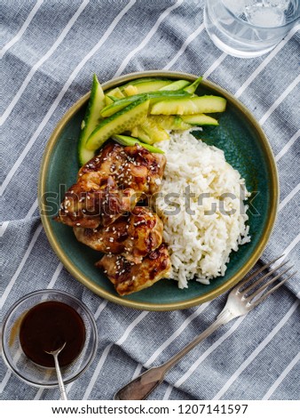 Hoisin Chicken. Traditional Asian cuisine. Chicken with sauce, rice and pickled cucumbers