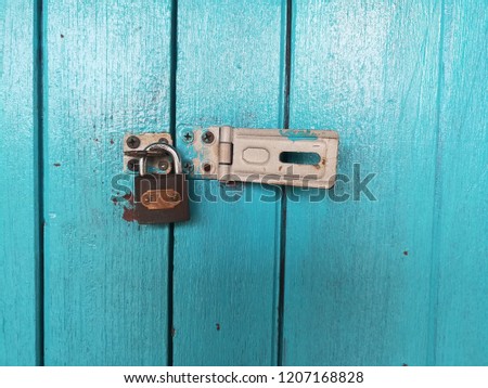 Black padlock on blue wooden door