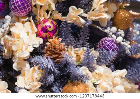 Christmas tree with pink and violet luxury balls on blurred background in mall. Close up. Abstract Xmas pattern.