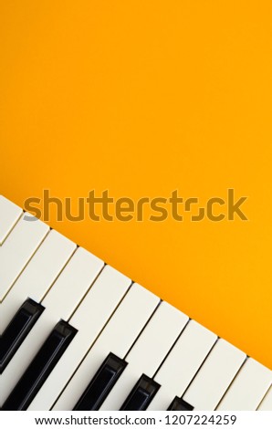 Vertical abstract orange background with the piano keys in the down-left corner