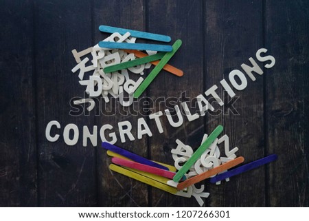 CONGRATULATIONS word by wood letters on wood background. 
