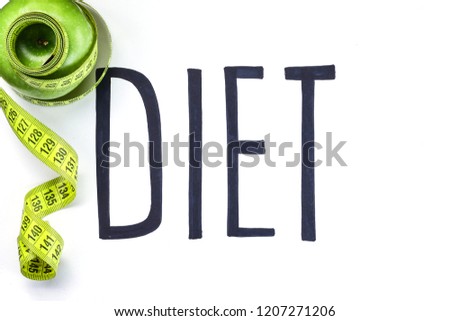 Diet concept. Handwriting word diet on white background and measuring tape on green apple.