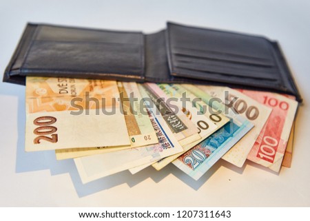 Background white, black men's wallet with bills of various currencies, isolated