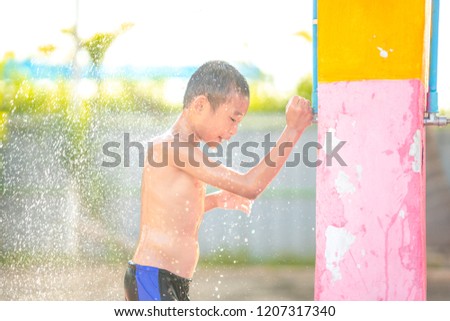 Asian happy kids taking bath from play swim in swimming pool.