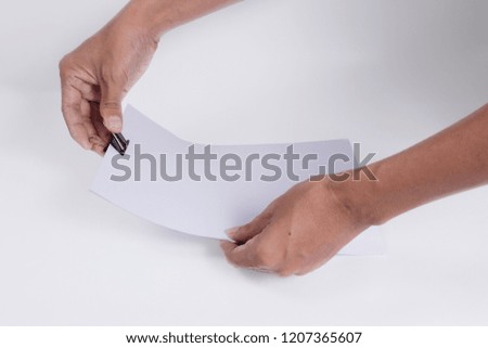 Man hand holding white paper with binder clips over white background. Concepcion is document Storage.