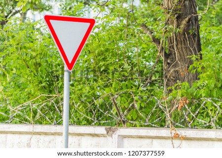 Road sign "give way" on the background of green.