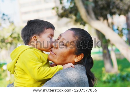 Tender portrait of little son kissing his mommy. Royalty-Free Stock Photo #1207377856