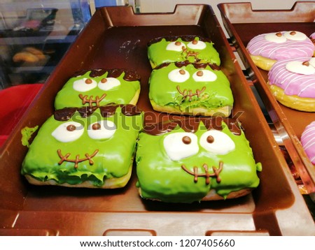Colorful donut shape pumpkin chocolate pink green and halloween day concept.selective focus