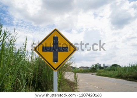 Warning sign at the intersection  on roadside.crossroads.Paved road in countryside Thailand.