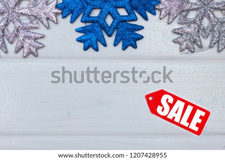 Christmas sale message with Christmas snowflakes in white wooden background.
