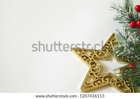 Fir tree branches, red berries, golden decorations on white background. Christmas backdrop.
