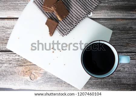 view on top Black coffee with brown chocolate waffle on wooden background.
