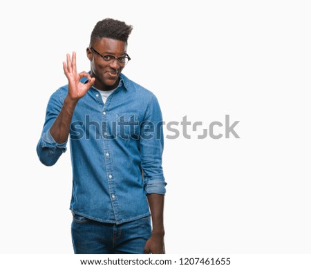 Young african american man over isolated background smiling positive doing ok sign with hand and fingers. Successful expression.