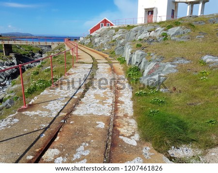 old concrete and metal trolley road with lighthouse background