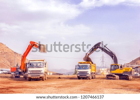View of the digging and loading in the construction site. Digging is the process of using some implement such as claws, hands, or tools, to remove material from a solid surface, usually soil or sand.