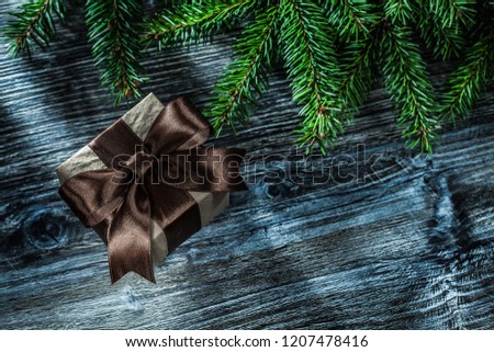 Christmas gift box fir branches on wooden board.