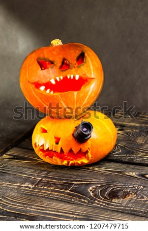 Halloween, two pieces or one, in the eye is a lantern camera with burning candles on a black background. Halloween celebration, celebration.