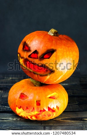 Halloween, two pieces or one, in the eye is a lantern camera with burning candles on a black background. Halloween celebration, celebration.