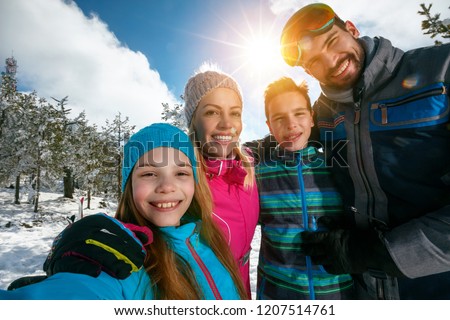 Happy family smiling and making selfie on winter ski vacation