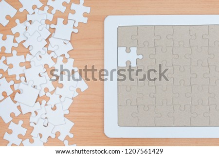 White jigsaw puzzle on wood table.