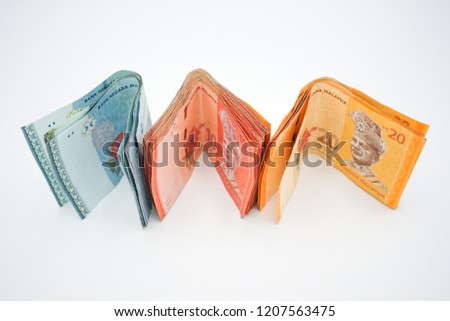 Selective Focus at a stack of Ringgit Malaysia Notes with white isolated background.