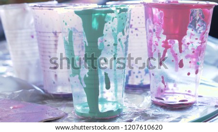 close-up, the remains of acrylic paint in the cups. after the process of drawing a picture of fluid art