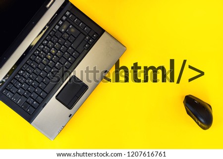 HTML Hyper Text Markup Language. laptop and vertical mouse on yellow background with html tag