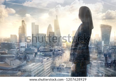 Young woman looking over the City of London at the early morning time. Future, new business opportunity and business success concept.