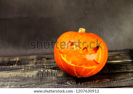 Halloween, two pieces or one, in the eye is a lantern camera with burning candles on a black background. Halloween celebration, celebration