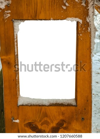 Blank empty wooden sign board covered in snow on a cold winters day