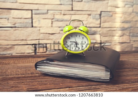 vintage clock on notepad on wooden desk