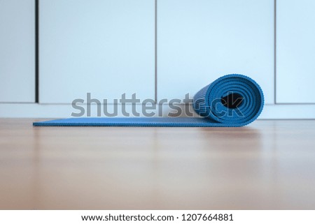 Rolling or folding blue yoga mat after a workout,Exercise equipment
Healthy fitness and sport concept