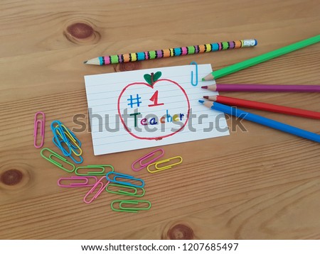 Number 1 Teacher, Note to teacher with colored pencils and paper clips lying on a wooden desk, School supplies, Teacher appreciation week, Best teacher, Education