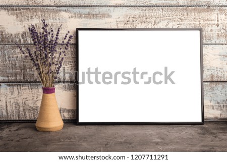Mock up of an empty frame poster on a wall of wooden boards. A bunch of lavender in a vase  