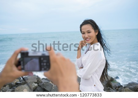 Young woman posing at camera by the sea