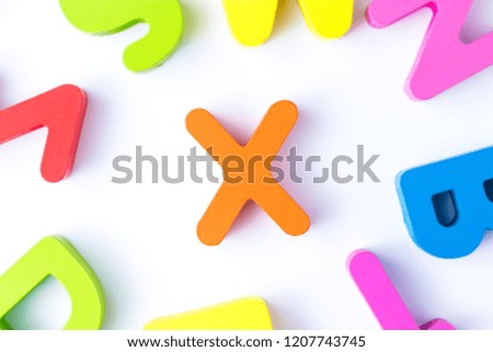 X letters in English made from wood bright colors.