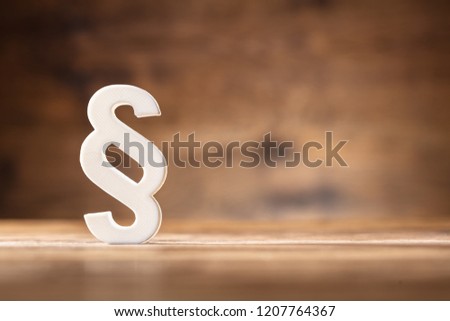 Close-up Of A White Paragraph Symbol On Wooden Desk